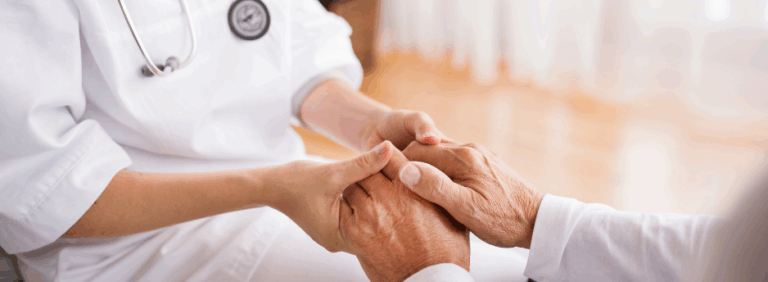 Foto di una dottoressa che tiene le mani di un anziano